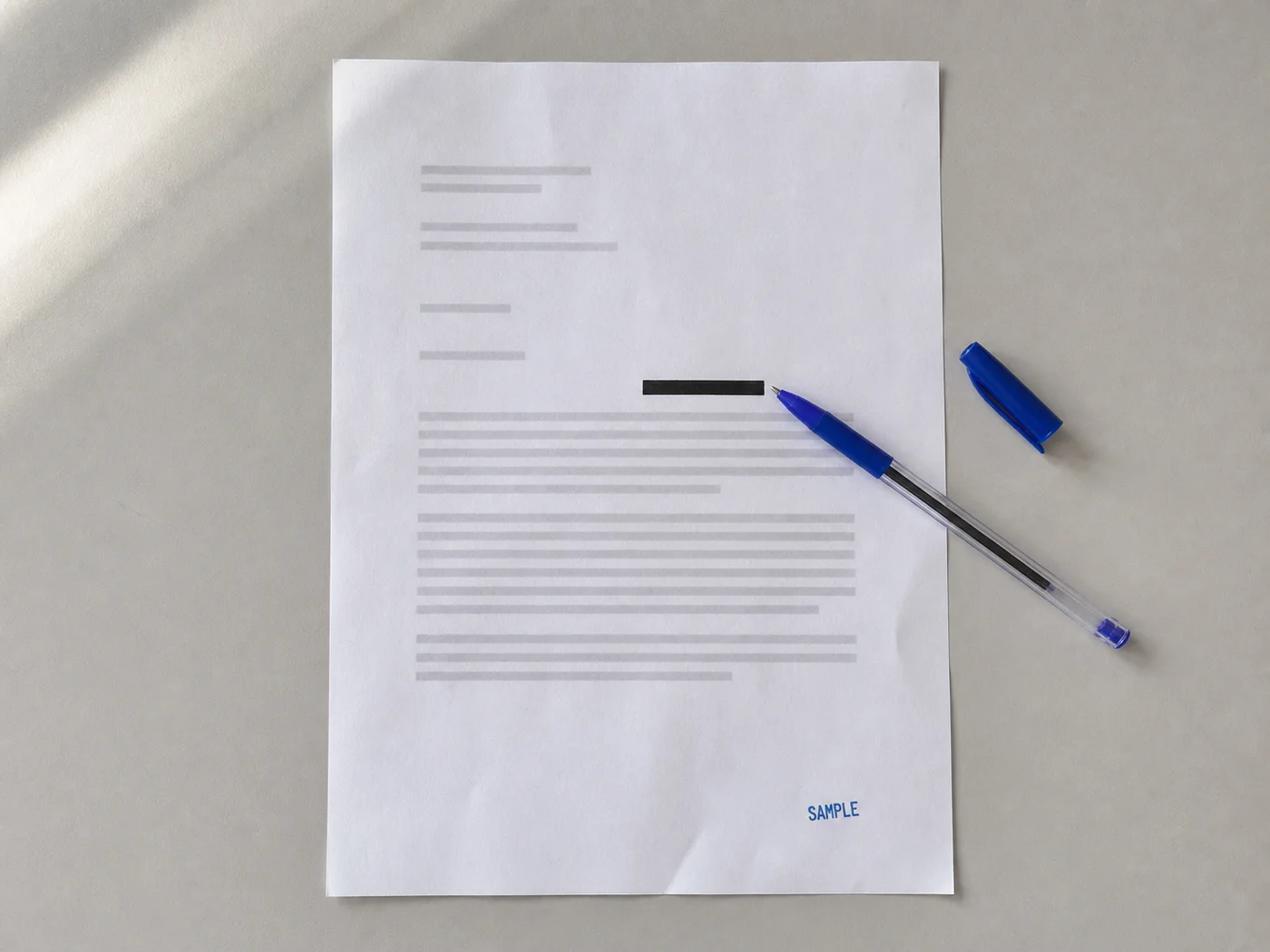 A clearly marked physical sample letter with a redacted identifier area and blue pen